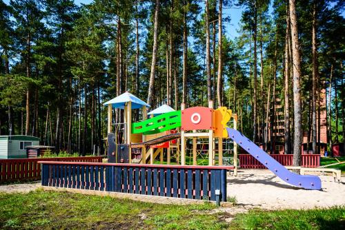 a playground with a slide in front of some trees at Porto Marine in Jūrmala
