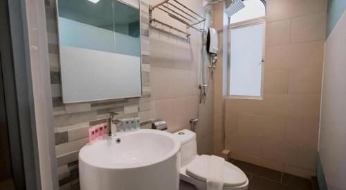 a small bathroom with a sink and a toilet at Kimal Hotel Taiping in Taiping