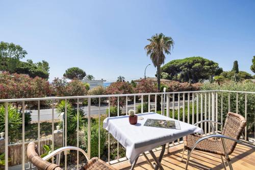 a patio with a table and chairs on a deck at Hotel Le Golfe Bleu in Cavalaire-sur-Mer