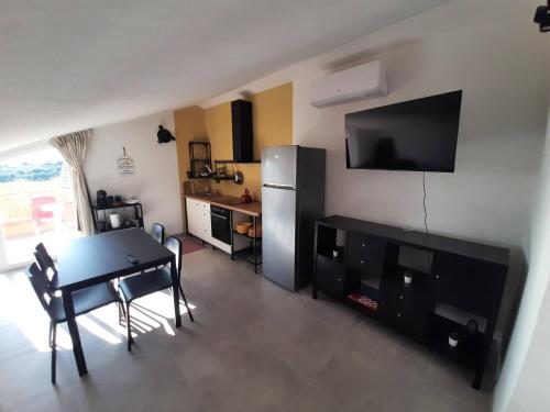 a living room with a table and a refrigerator at Terrazza Dante in San Vito Chietino