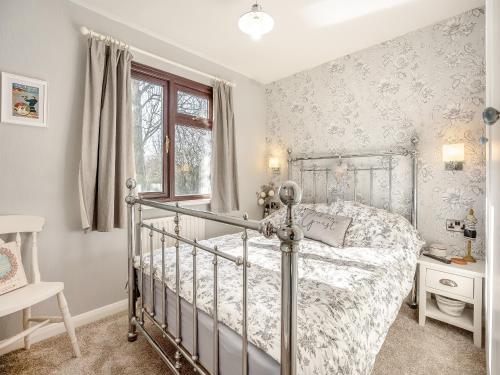 a bedroom with a bed and a window at Green Poplars in Gurnard
