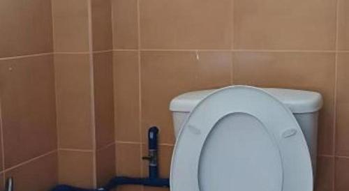 a bathroom with a white toilet in a stall at OYO 90785 Pandan Hotel in Kota Kinabalu