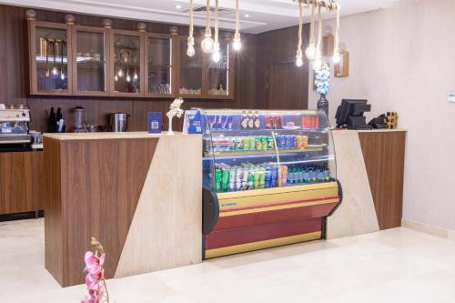 a drink counter in a restaurant with a drink cooler at Sumou Hotel Al Khobar in Al Khobar