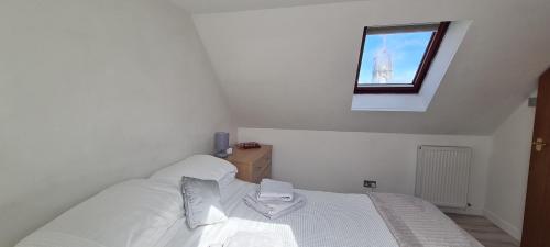 a bedroom with a white bed and a window at Buckie Town Centre Stay in Buckie