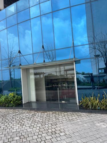 a building reflected in the glass facade at belliza apartment in Surat