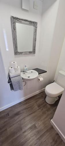 a white bathroom with a sink and a toilet at Buckie Town Centre Stay in Buckie