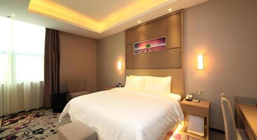 a hotel room with a white bed and a window at Shenzhen Lavande Hotel Airport Terminal Branch in Shenzhen