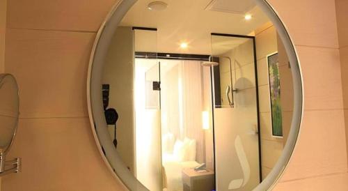 a mirror in a bathroom with a shower at Shenzhen Lavande Hotel Airport Terminal Branch in Shenzhen