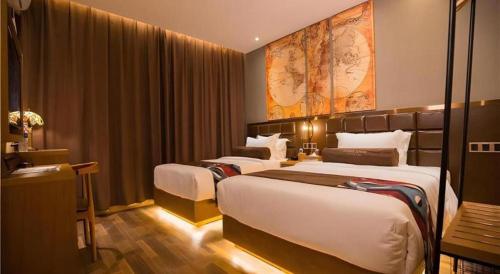 a hotel room with two beds and a map on the wall at James Joyce Coffetel·Kaifeng Drum Tower in Kaifeng