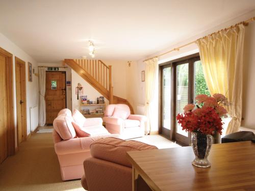 a living room with two couches and a vase with flowers at High Farm Barn in Brisley