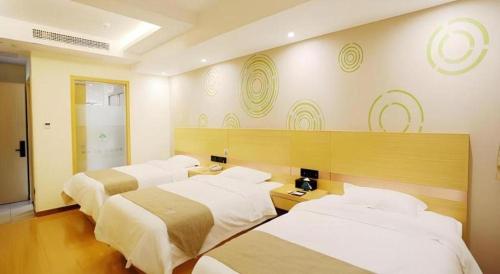 a hotel room with three beds in a room at GreenTree Inn Chaohu High Speed Rail East Station in Chaohu