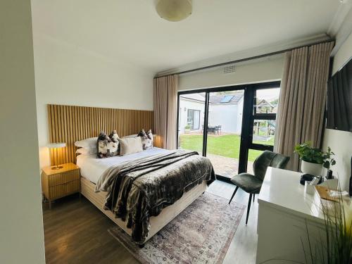 a bedroom with a bed and a large window at 2 On Lismore Guesthouse in Tokai