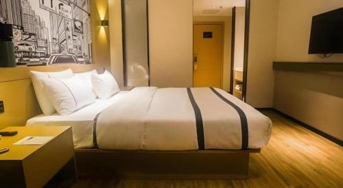 a bedroom with a large bed in a hotel room at City Comfort Inn Ji'an South Administrative Center in Ji'an