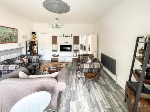 a living room with two couches and a table at Osborne Place in Rothesay