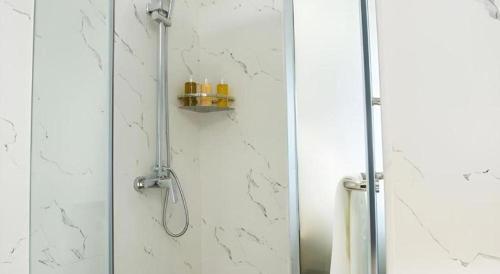 a shower with a glass door with candles on it at Borrman Hotel Zhuhai Gongbei Port Fuhuali Light Rail in Zhuhai