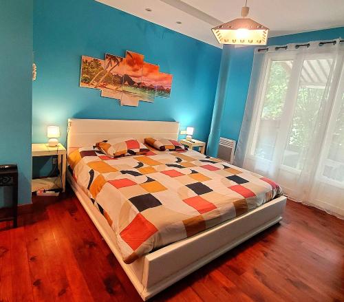 a bedroom with a bed with a colorful comforter at L'Odyssée VILLA ILOA in Dommartemont