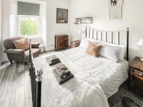 a bedroom with a bed and a chair in it at Osborne Place in Rothesay