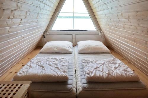 a bed in a small room with a window at Seeperle 11 mit Ruderboot - ABC211 in Bad Kleinen