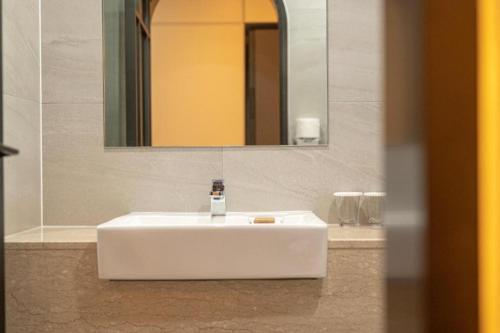 a white sink in a bathroom with a mirror at HOTEL D EDITION in Daejeon