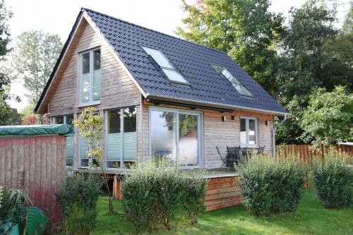 a small house with a solar roof on a yard at Ferienhaus Reiherweg in Bedekaspel
