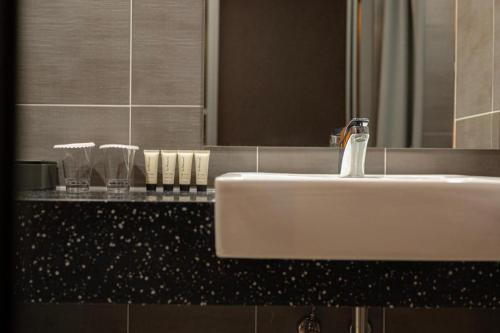 a white sink in a bathroom with a mirror at HOTEL D EDITION in Daejeon
