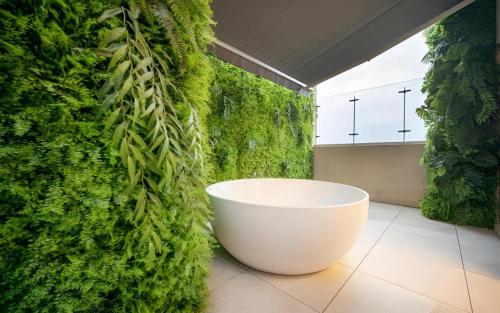a bathroom with a green wall with a bath tub at HOTEL D EDITION in Daejeon