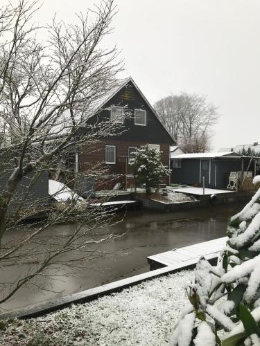 a house covered in snow next to a river at Ferienwohnung Ambiente in Bedekaspel