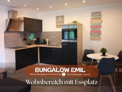 a kitchen with a refrigerator and a table with chairs at Bungalow Grünewalder Lauch in Lauchhammer