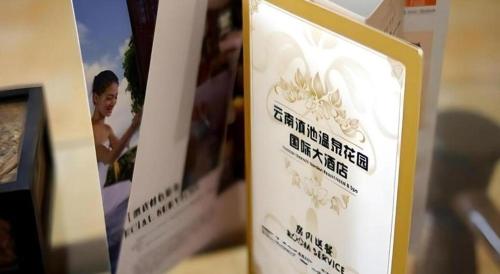 a sign for a hotel with a picture of a woman at Kunming Dianchi Garden Hotel & Spa in Kunming