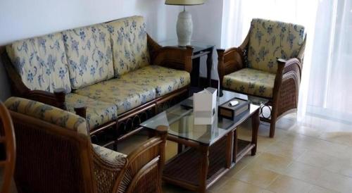 a living room with a couch and two chairs and a table at Kunming Dianchi Garden Hotel & Spa in Kunming