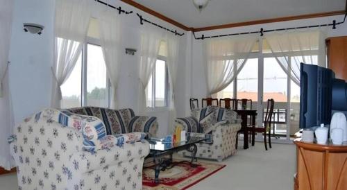 a living room with two couches and a table at Kunming Dianchi Garden Hotel & Spa in Kunming