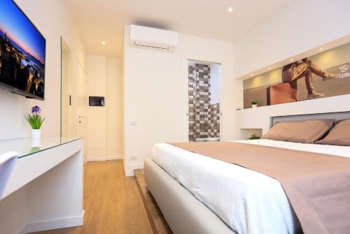 a bedroom with a large bed and a tv at F53 Kevin's Charming Houses in Alghero