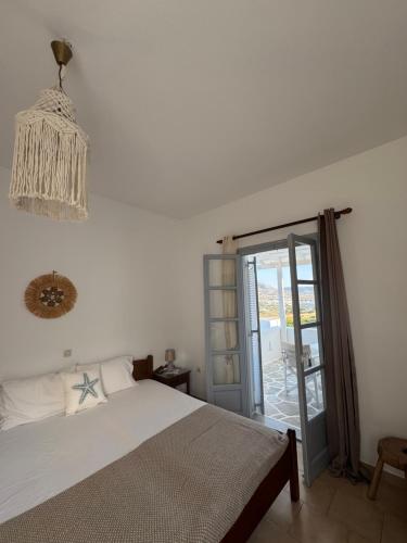 a bedroom with a bed and a glass door at Kirki Rooms on the Hill in Parikia