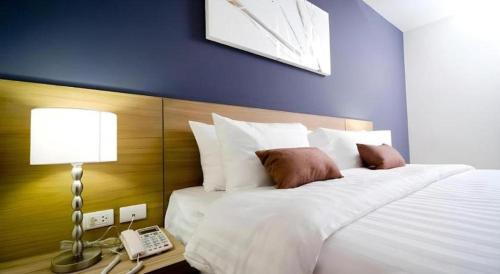 a bedroom with a bed with a phone and a lamp at Pannapat Place in Bangkok