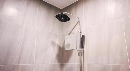 a shower with a shower head in a bathroom at Hotel Seowa in Gimhae