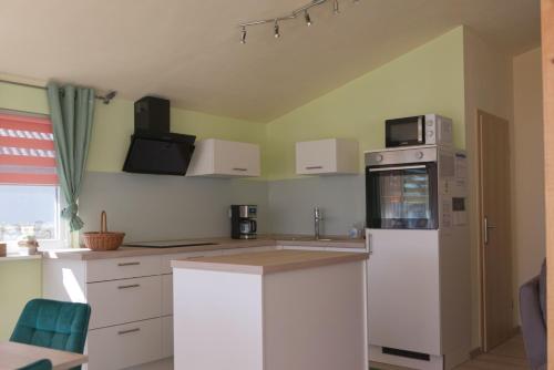 a kitchen with a white refrigerator and a microwave at Ferienhaus An der Riede in Bedekaspel