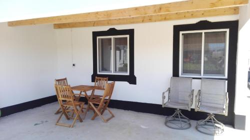 a patio with chairs and a table and two windows at Quinta do Chico Feijão in Lajes