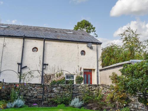un antiguo edificio blanco con una puerta roja en Barn 2, en Ulverston
