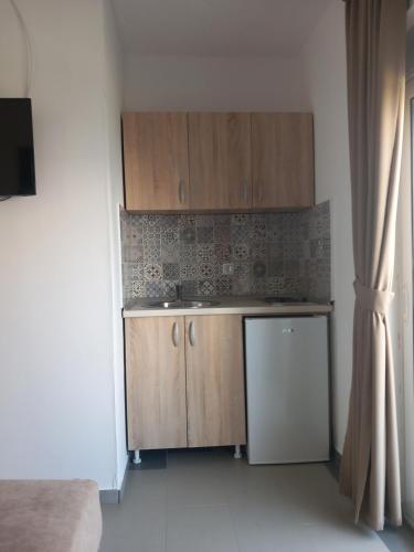 a small kitchen with wooden cabinets and a refrigerator at Vila Nina Donji Štoj in Ulcinj