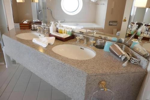a bathroom counter with two sinks and a mirror at Yokohama Royal Park Hotel in Yokohama