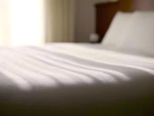 a close up of a white bed in a room at Yokohama Royal Park Hotel in Yokohama