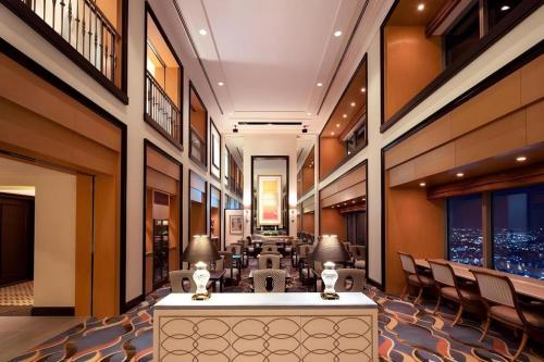 a hotel lobby with a reception desk and chairs at Yokohama Royal Park Hotel in Yokohama