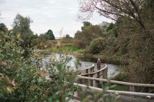 a man fishing on a bridge over a river at Oiu sadama Iglupark in Oiu