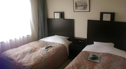 Ένα ή περισσότερα κρεβάτια σε δωμάτιο στο Takada Terminal Hotel