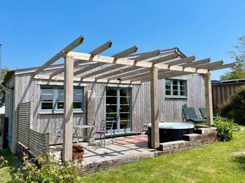 a pergola with a table and chairs in a yard at The Dairy - Luxurious Hideaway on The Lizard in Cury
