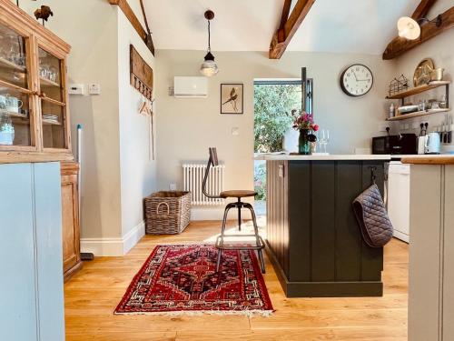 a kitchen with a counter and a rug on the floor at The Dairy - Luxurious Hideaway on The Lizard in Cury