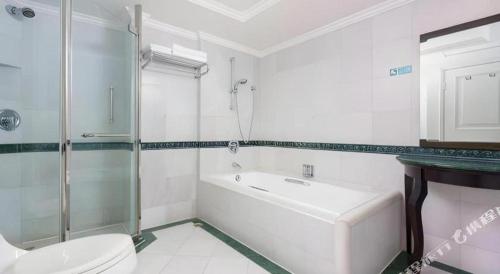 a bathroom with a toilet and a shower and a sink at Shantou Golden Gulf Hotel in Shantou