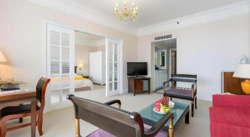 a living room with a room with a bed and a couch at Shantou Golden Gulf Hotel in Shantou