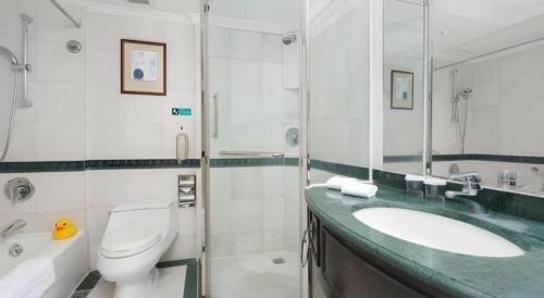 a bathroom with a sink and a toilet and a shower at Shantou Golden Gulf Hotel in Shantou
