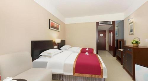 a hotel room with a bed and a couch at Shantou Golden Gulf Hotel in Shantou